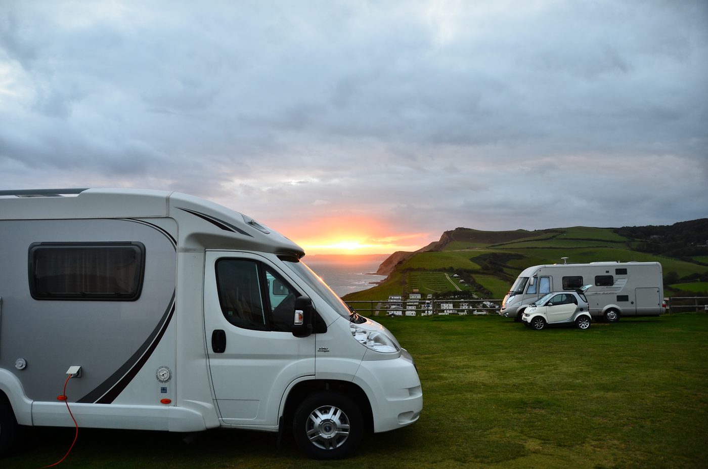 Camper op een kampeerplek aan de kust bij zonsondergang